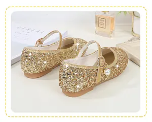 Close-up of golden sequin Mary Jane shoes with pearl pendant and buckle strap detail
