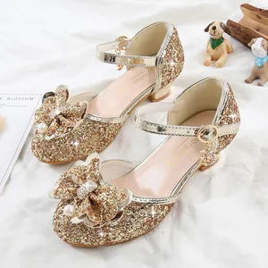 Detailed view of girls gold sequin princess shoes with pearl bow and heart charm