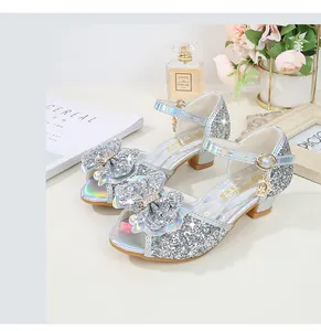 Close-up of girls silver glitter sandals with sequined bow and pearl details