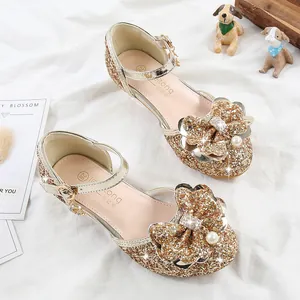 Detail of gold sequin girls Mary Jane shoes with large rhinestone bow and pearls
