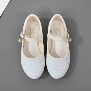 Close-up of glitter sequins texture and pearl bell charm on girls princess Mary Jane shoe