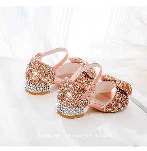 Detailed view of pink sparkling girls' princess shoes with rhinestones and large bow detail