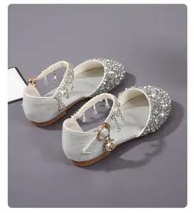 Detalle de zapatos plateados de princesa para niña con lentejuelas y puntera de strass