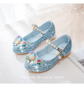 Detailed close-up of blue sequined girls princess shoes with pearl straps and floral decor