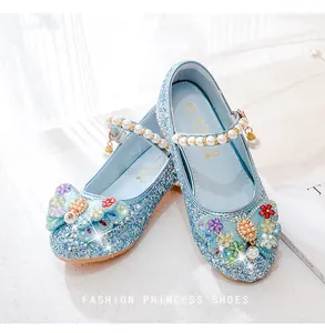 Close-up of blue sequined princess shoes with pearl straps and floral rhinestone details