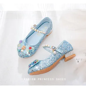 Detail of blue sequined princess shoes with floral bow and pearl buckle strap