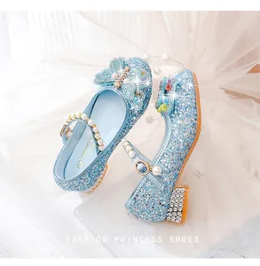 Gros plan d'une chaussure fille bleu clair avec paillettes, perles et papillon 3D