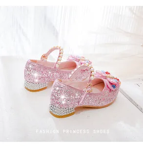 Close-up of pink glitter girls princess shoes with pearl strap and rhinestone low heel
