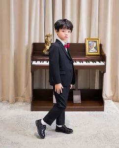Klassischer vierteiliger Jungenanzug in Schwarz mit Jacke, Hose, Hemd und roter Fliege