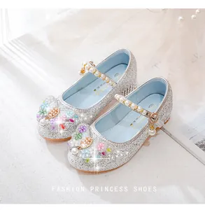 Detail of silver sequin princess shoes featuring a pearl strap and floral bow