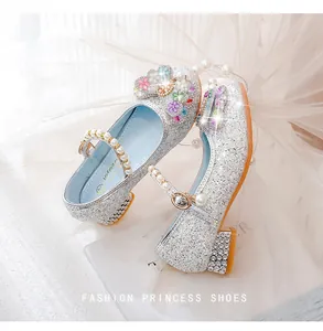 Close-up of girls silver princess shoes with sequins, pearl straps and floral details
