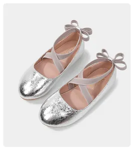 Close-up of silver glitter girls' ballet flats with elastic straps and a rear bow detail