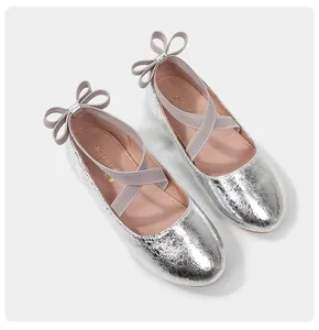 Detail view of girls silver Mary Jane shoes with metallic texture and bow accent