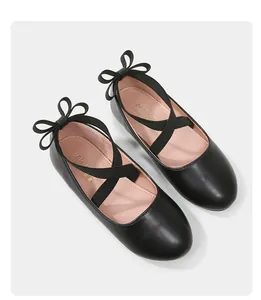 Detailed top view of black Mary Jane girls shoes with cross straps and back bows