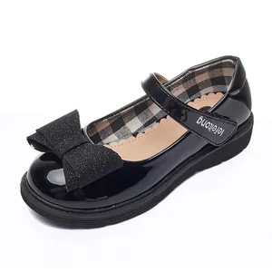 Classic black patent leather girls' Mary Jane shoes with a large glitter bow and velcro strap