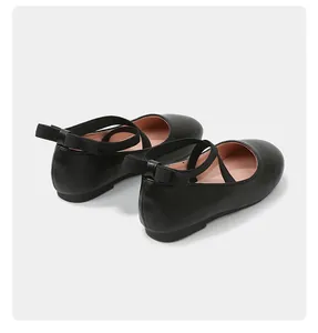 Detail view of girls' black matte Mary Jane shoes with elastic straps and heel bow
