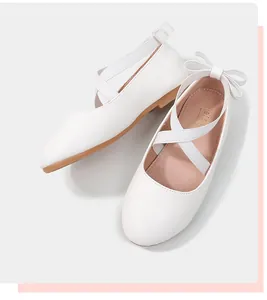 Detail of white girls princess shoes with elastic cross straps and rear bow decoration