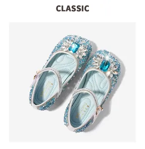 Detail of blue sequined girls Mary Jane shoes with large sapphire-style gemstone decoration