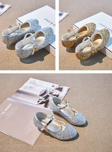 Close-up of glitter Mary Jane shoes with heart charms in gold and silver colors