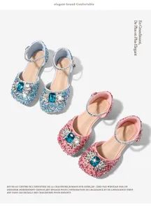 Detail of glitter princess shoes featuring blue faux gemstone and rhinestone floral pattern