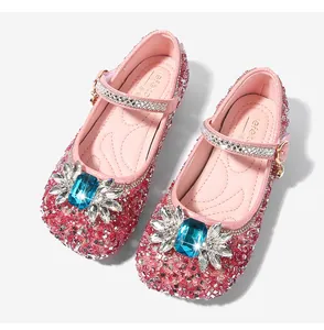 Detail of pink sequin Mary Jane shoes featuring a large blue gem and rhinestone buckle