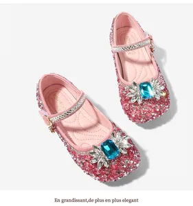 Detail of pink sparkly Mary Jane flats with blue crystal and wing-shaped rhinestone ornaments