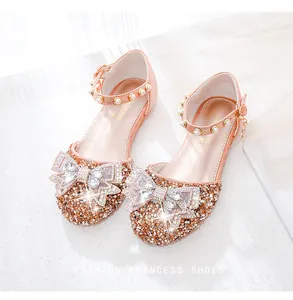 Détail de chaussures princesse pailletées avec nœud en strass et bride en perles