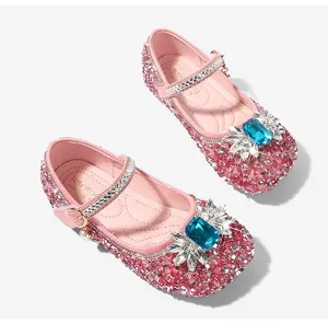 Close-up of pink glitter princess shoes featuring a large blue gemstone and sparkling rhinestones