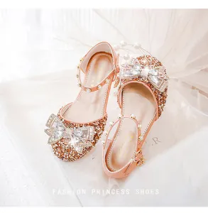 Détail du nœud en strass étincelant et de la bride en perles sur sandales roses fille