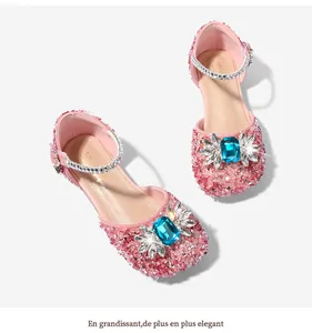 Macro detail of pink glitter princess sandals with a large blue gemstone on the toe