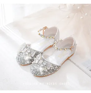 Détail de chaussures de princesse argentées pour filles avec nœud en strass et perles