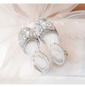 Détail de chaussures de princesse argentées pour filles avec strass et bride en perles