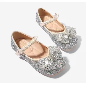 Détail de chaussures Mary Jane argentées scintillantes avec nœud en strass et perles