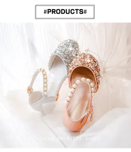 Detail von glitzernden Mädchen-Prinzessin-Schuhen mit Perlenriemen in Rosa und Silber