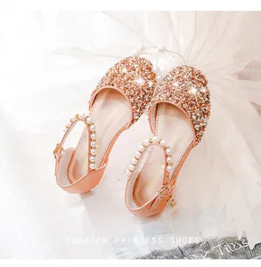 Nahaufnahme glitzernder goldener Mädchen-Prinzessin-Sandalen mit Perlen und Strasssteinen