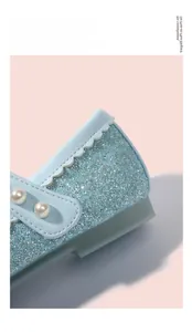 Détail de chaussures de princesse à paillettes bleues avec boucle en perles et semelle