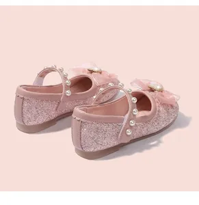 Close-up of pink sequin Mary Jane shoes with mesh bow, pearls and heart rhinestone