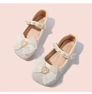 Close-up of glittery Mary Jane shoe with pearl strap and large mesh bow with heart crystal