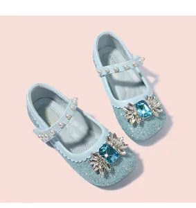Détail de chaussures Mary Jane bleues à paillettes avec fleur en cristal et perles