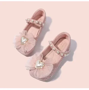 Dettaglio scarpe Mary Jane rosa con paillettes, fiocco in rete e perla a cuore