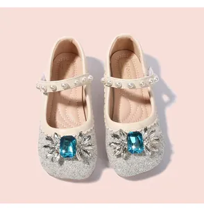 Détail de babies argentées à paillettes avec pierre bleue et bride en perles