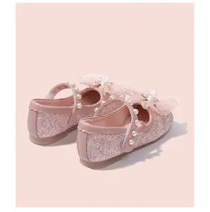 Dettaglio scarpe da principessa rosa glitterate con perle e fiocco in rete
