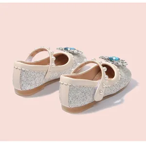 Détail de chaussures de princesse argentées à paillettes avec flocon de cristal et perles