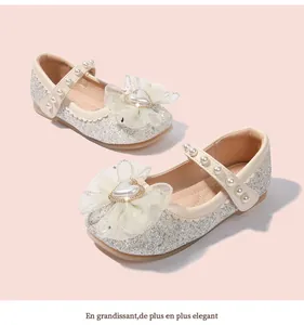 Dettaglio scarpe da principessa con paillettes argento, fiocco in rete e cinturino