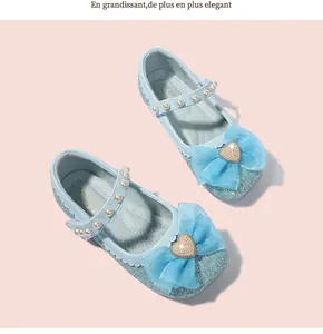 Close-up of glittery blue Mary Jane shoes with mesh bow and pearl heart detail