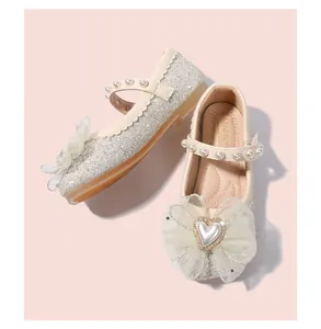 Dettaglio ravvicinato di paillettes argentate e fiocco in rete con perla a cuore su scarpe