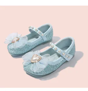 Dettaglio scarpe bimba glitter blu con fiocco in tulle e cinturino di perle
