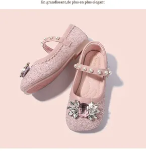 Détail de chaussures de princesse à paillettes roses avec broche en cristal et perles