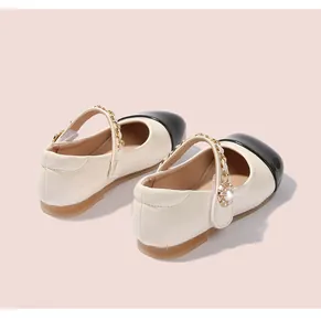 Detailansicht der Mädchen Mary Jane Schuhe mit beigem Lackleder und schwarzer Kappe
