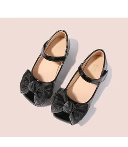 Vue de dessus de babies en cuir verni noir pour filles avec un grand nœud en résille